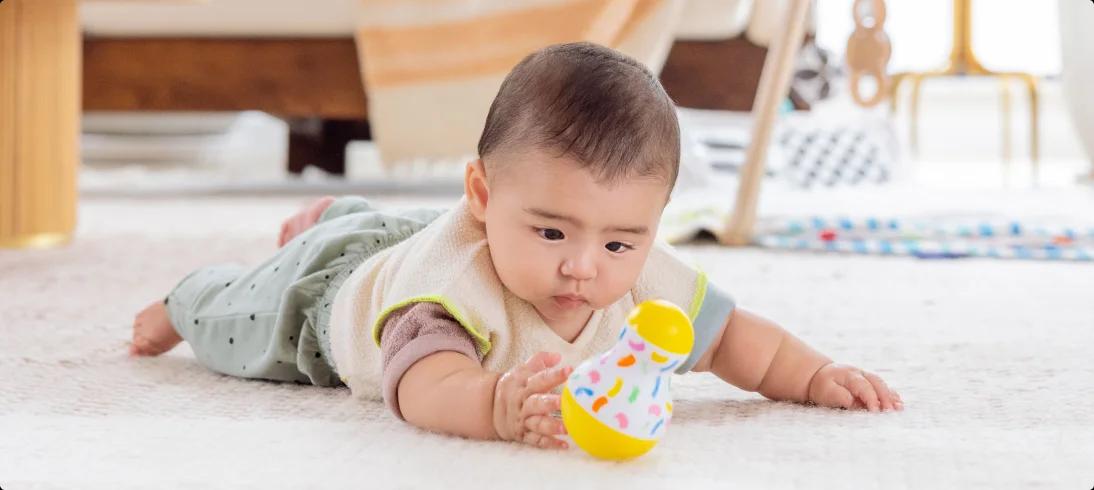 Baby reaching for the Tummy Time Wobbler from The Senser Play Kit