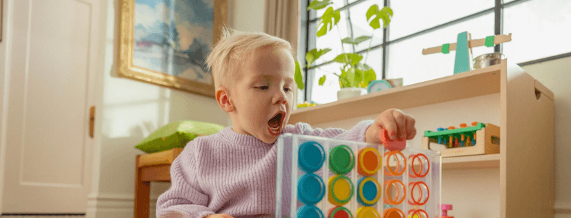 Child with the Drop & Match Dot Catcher from The Helper Play Kit